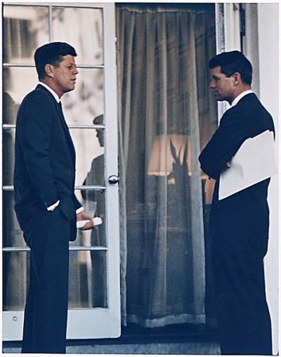 John F. Kennedy and his brother Robert F. Kennedy consulting.